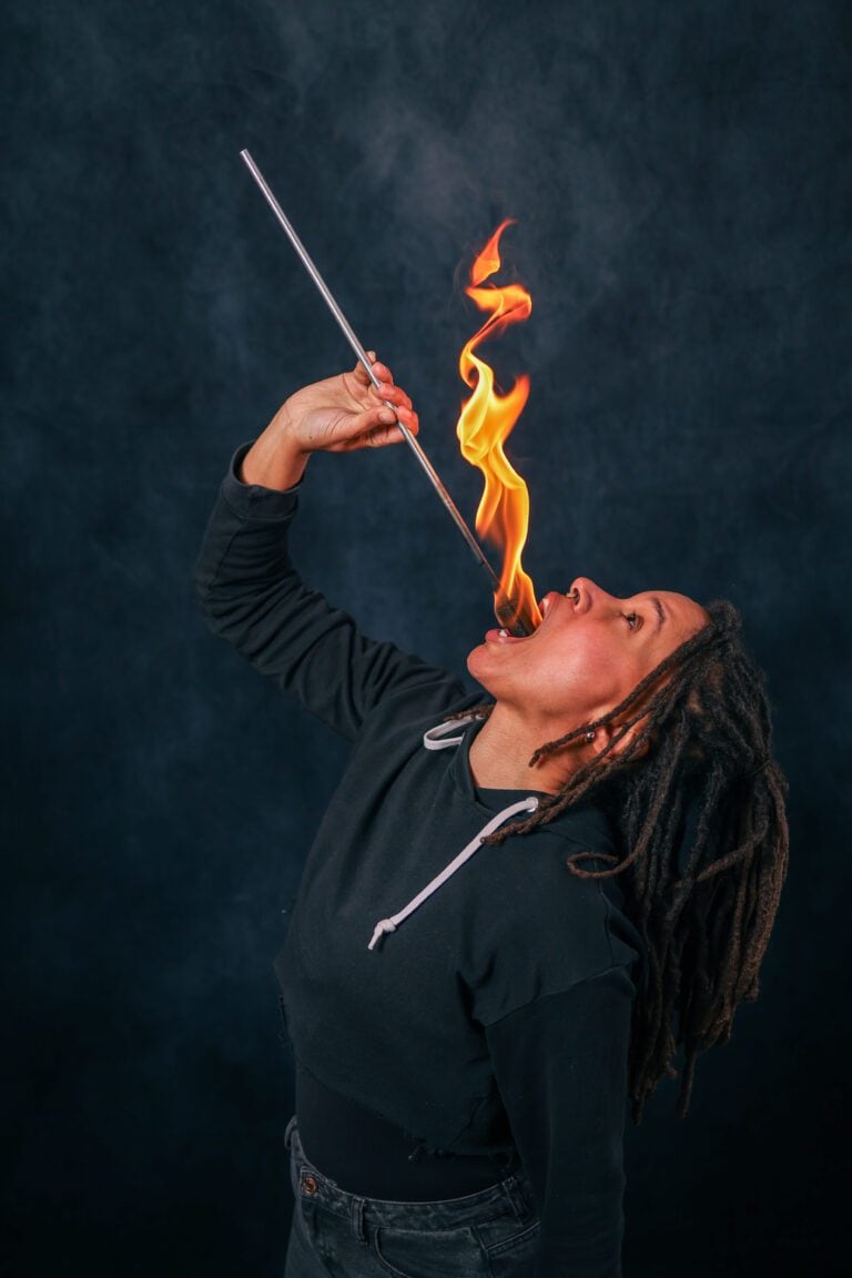 Close-up of a fire eating student holding a lit torch